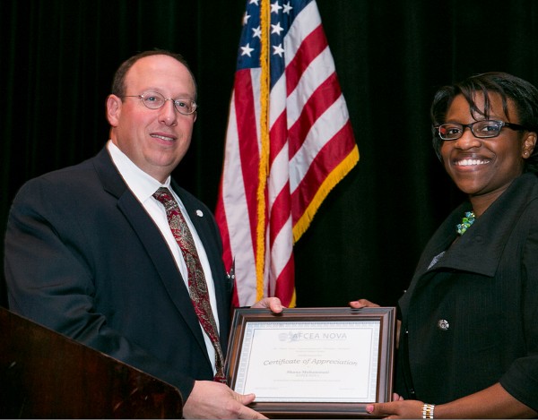 In December, Shana Muhammad, Strategic Resources Incorporated, accepts the chapter's SuperNOVA Award from Cusano.